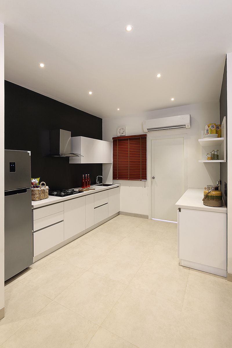 a well designed kitchen equipped with a fridge, chimney and sleek cabinets for everyday use.