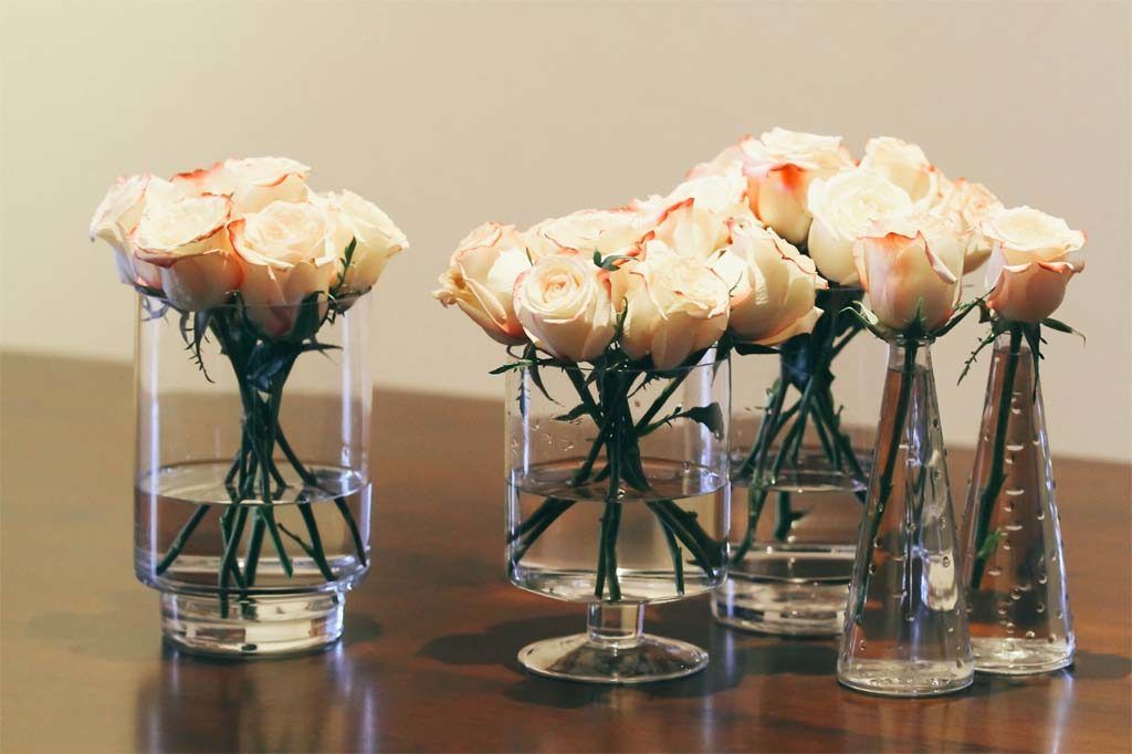 rose flower arrangements in glass bottles