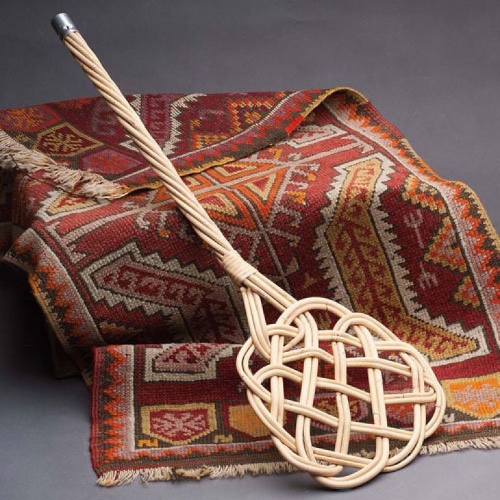 Use carpet beater to clean Persian rug.