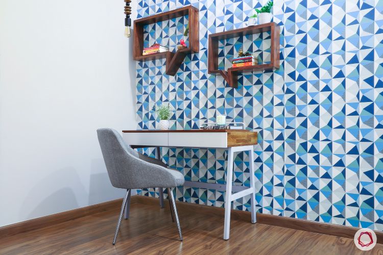 a-room-with-blue-and-white-geometric-wallpaper-and-a-desk