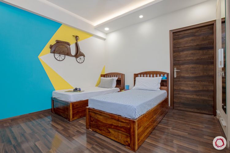 top interior designer kids room with two single beds and accent wall with scooter
