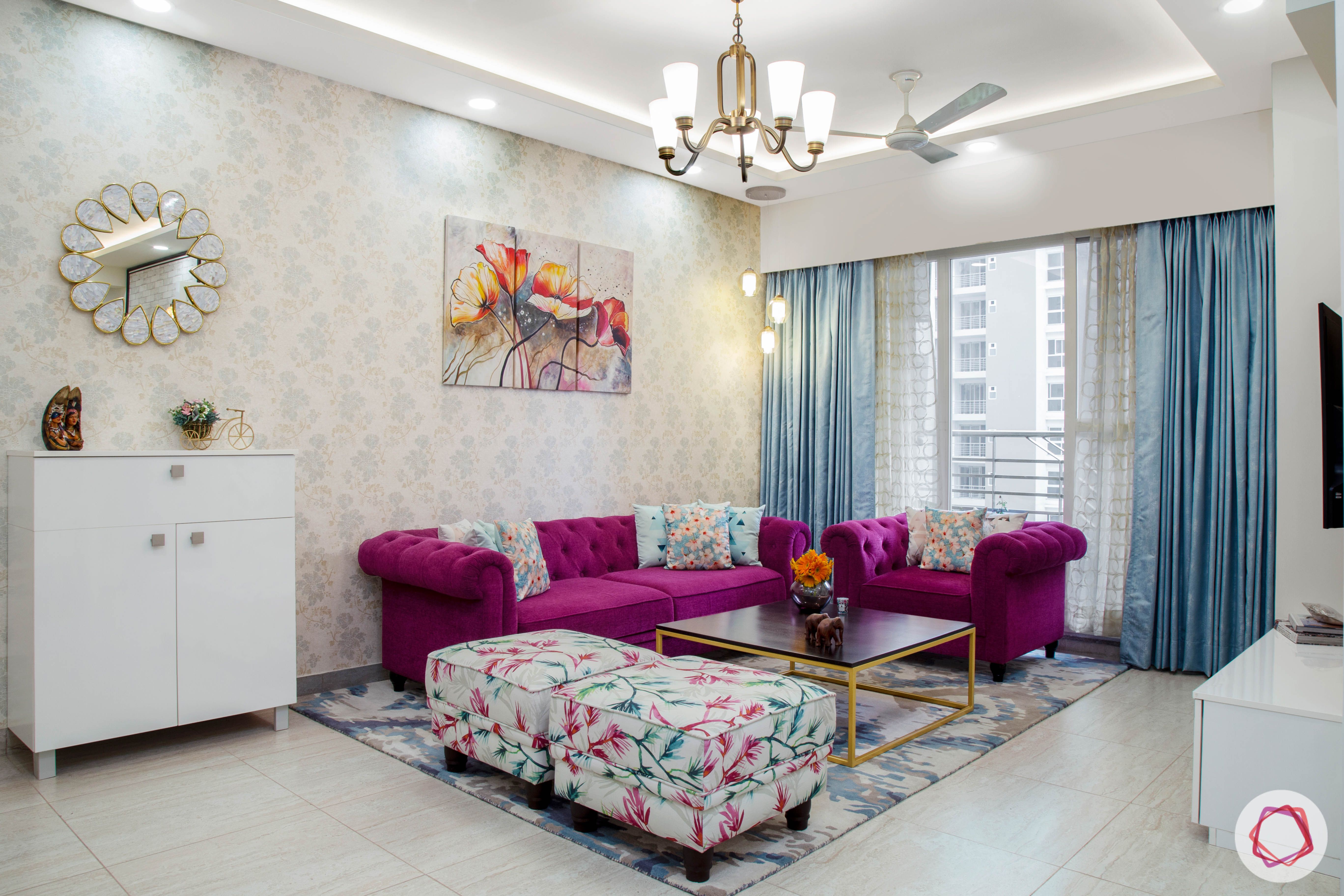 Cleo county noida_living room with purple colour sofa and floral ottomans