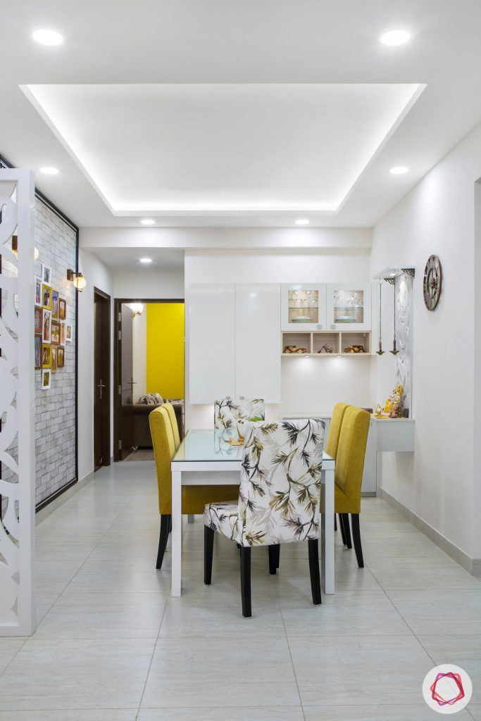 Cleo county noida_dining room with mustard yellow chairs and white crockery unit
