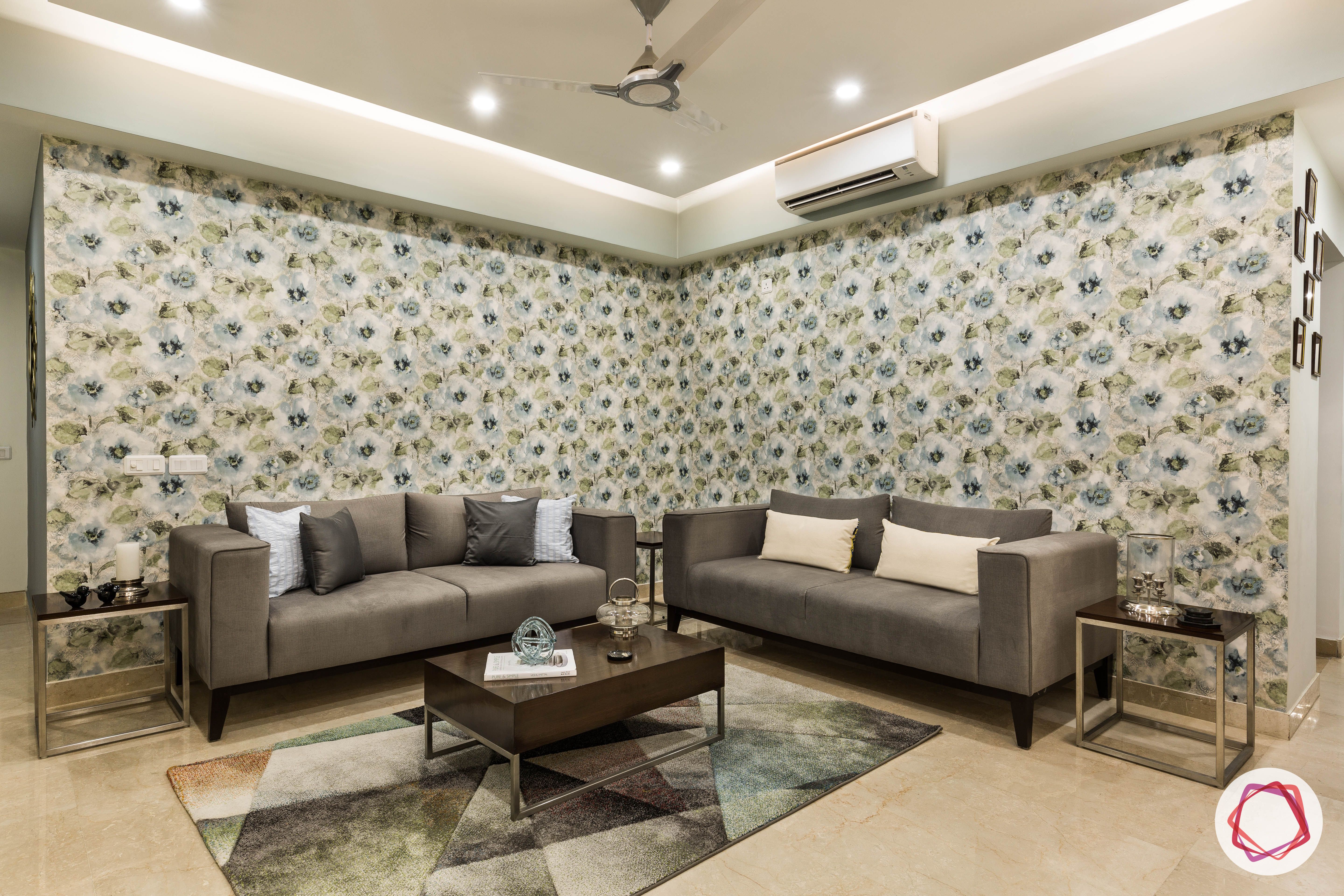 flat interior design-floral-living room-grey sofas-wallpaper-patterned rug-wooden coffee table-false ceiling-side tables
