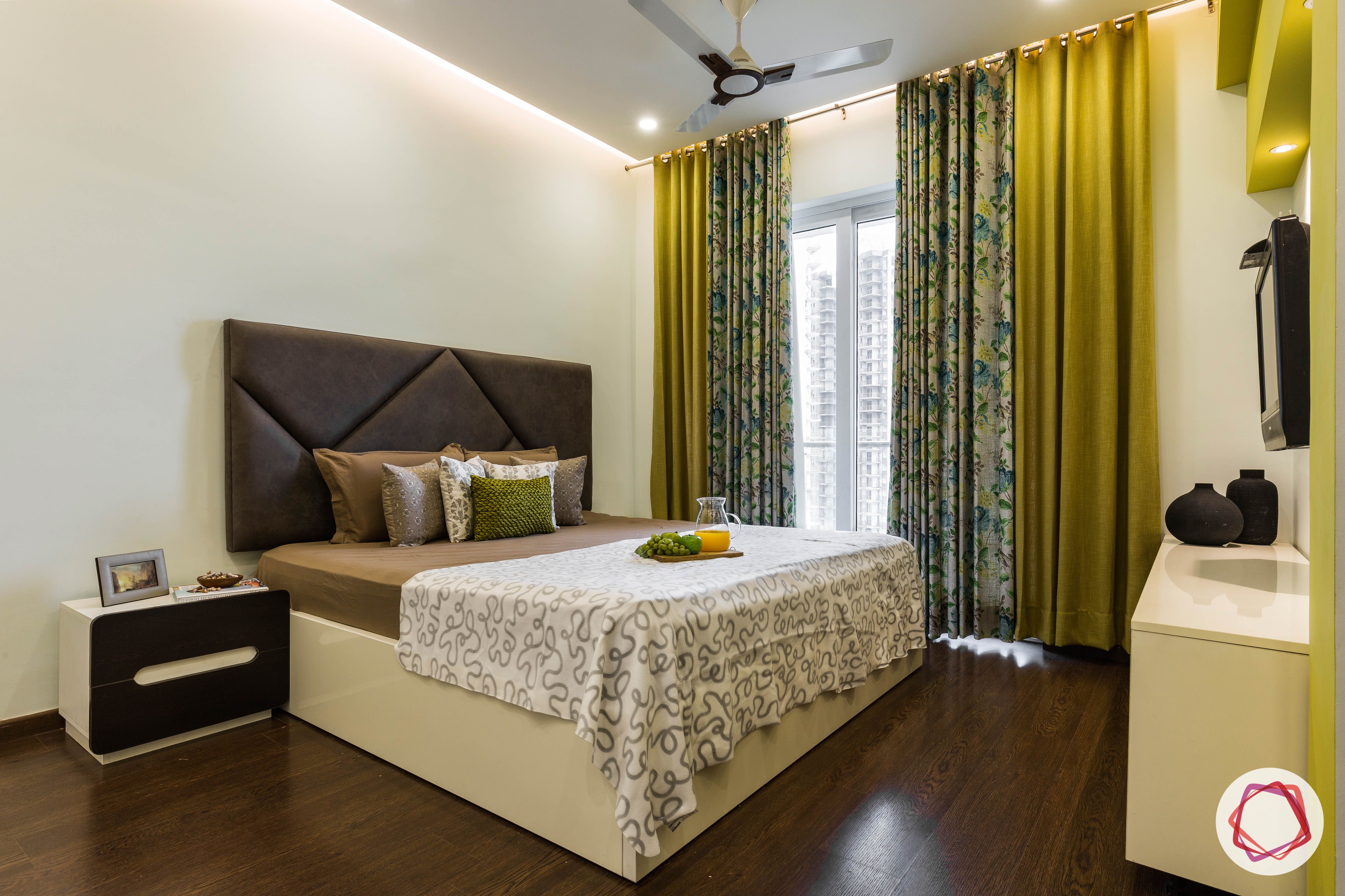 flat interior design-master bedroom-grey headboard-bedside table-wooden flooring-mustard curtains
