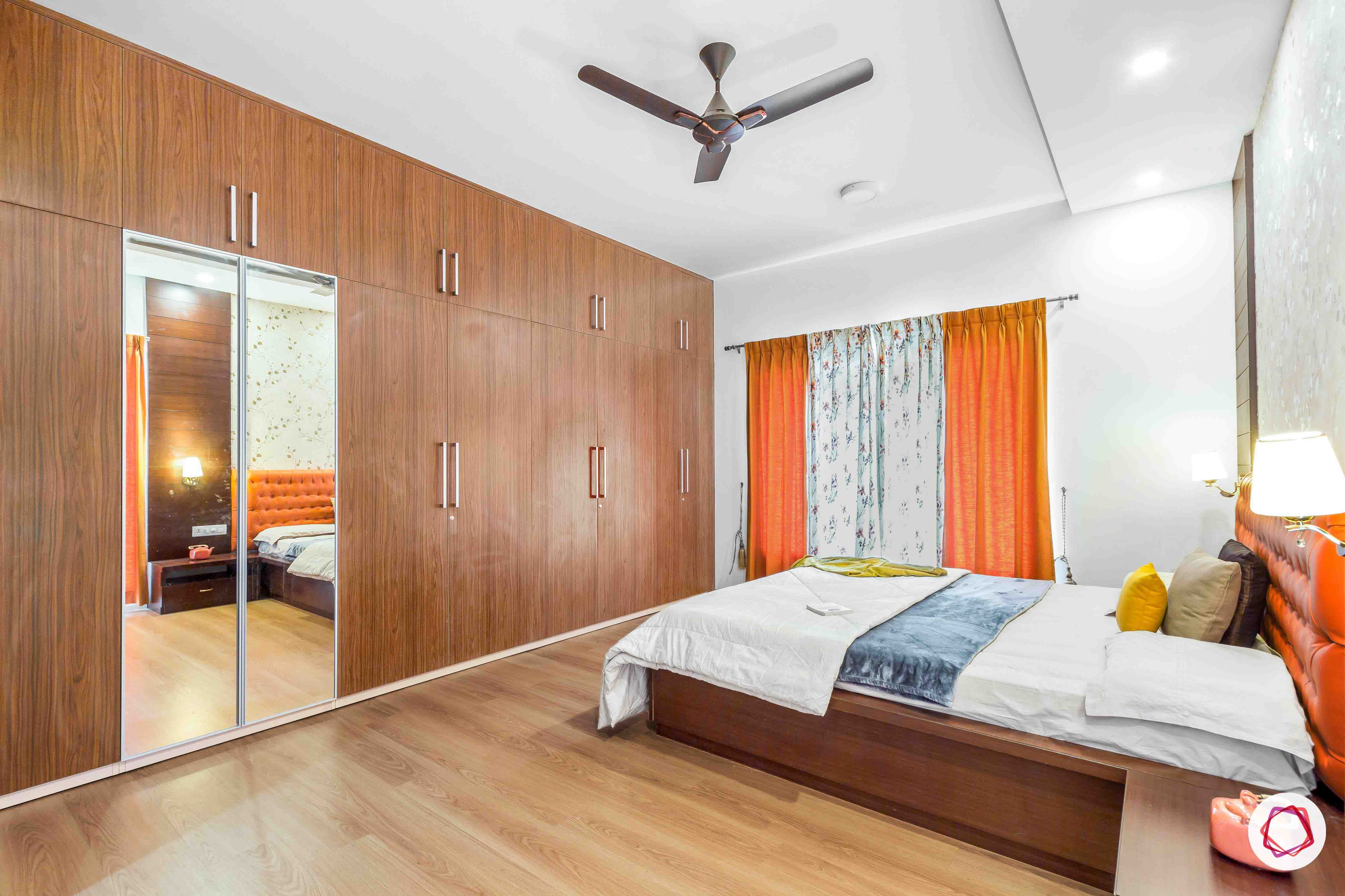 sobha forest view-master bedroom-rust orange-wooden tones-laminate finish wardrobe-wooden flooring