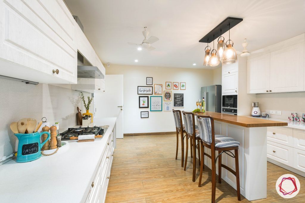 4bhk house plan-white kitchen designs-quartz countertops-white countertops-island kitchen designs-breakfast counter in kitchen-wooden flooring designs-high bar chairs