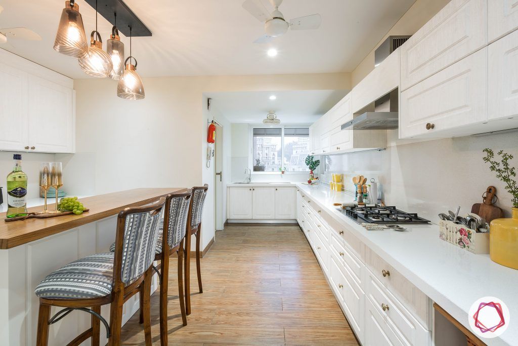 4bhk house plan-white kitchen designs-quartz countertops-white countertops-island kitchen designs-breakfast counter in kitchen-wooden flooring designs-all white kitchen-kitchen lighting ideas