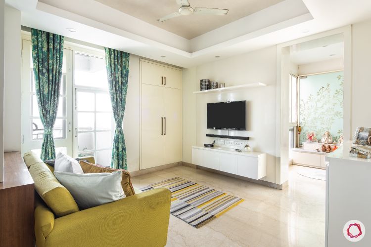 flat-in-faridabad-living-room-casual-TV-white-panel-yellow-sofa-wardrobe-rug
