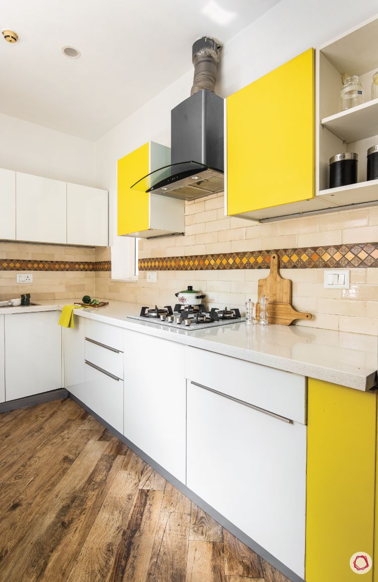 flat-in-faridabad-kitchen-yellow-white-cabients-flooring-wooden-chimney-groove-handle
