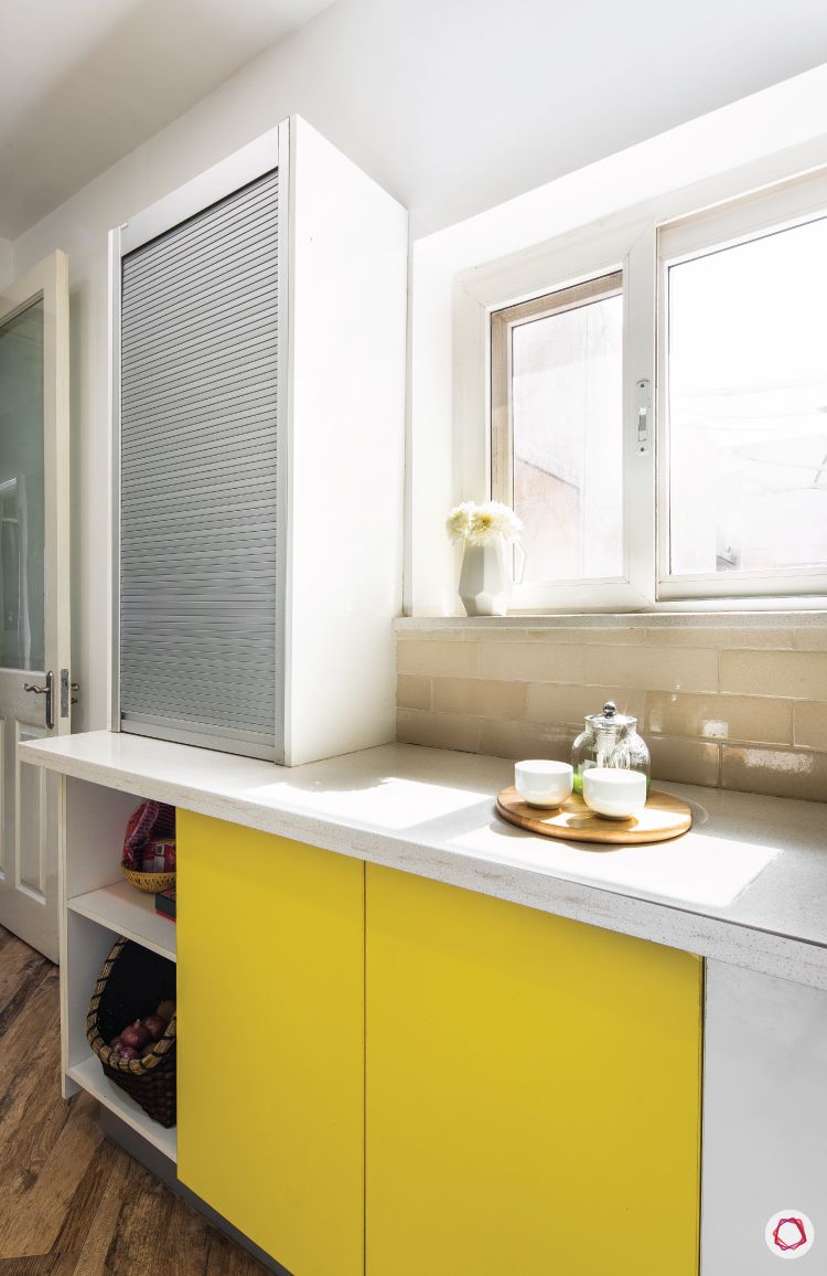 flat-in-faridabad-kitchen-roller-shutter-yellow-lower-cabinets-ceramic-tiles
