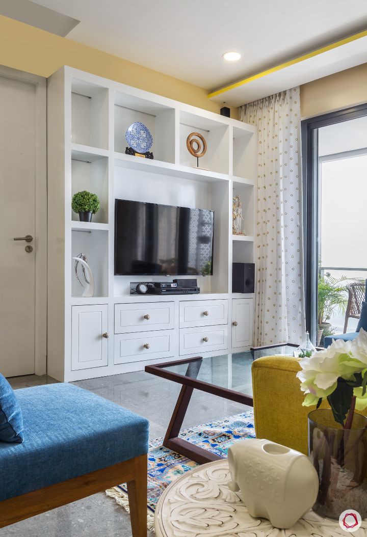 living-room-white-TV-unit-glass-table-blue-chair-balcony