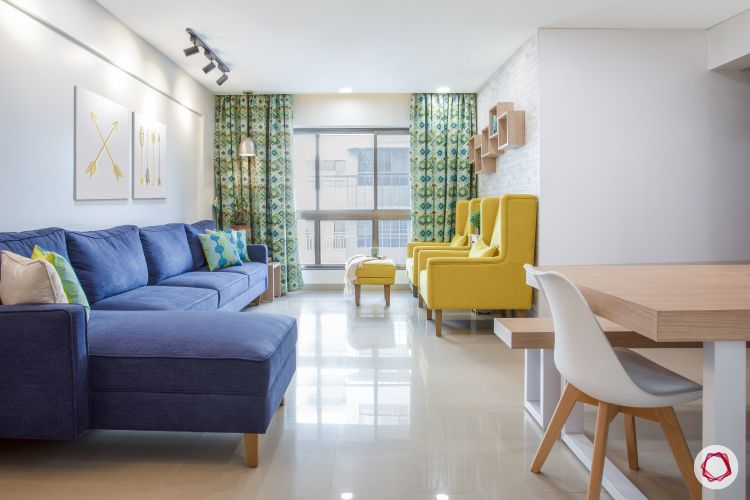 godrej homes-mumbai home-living room-bright living room-yellow chairs-blue sofa-track lights-white walls