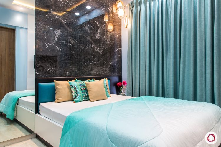 best interior designers in mumbai-bedroom-marble tiles-accent wall-blue curtains