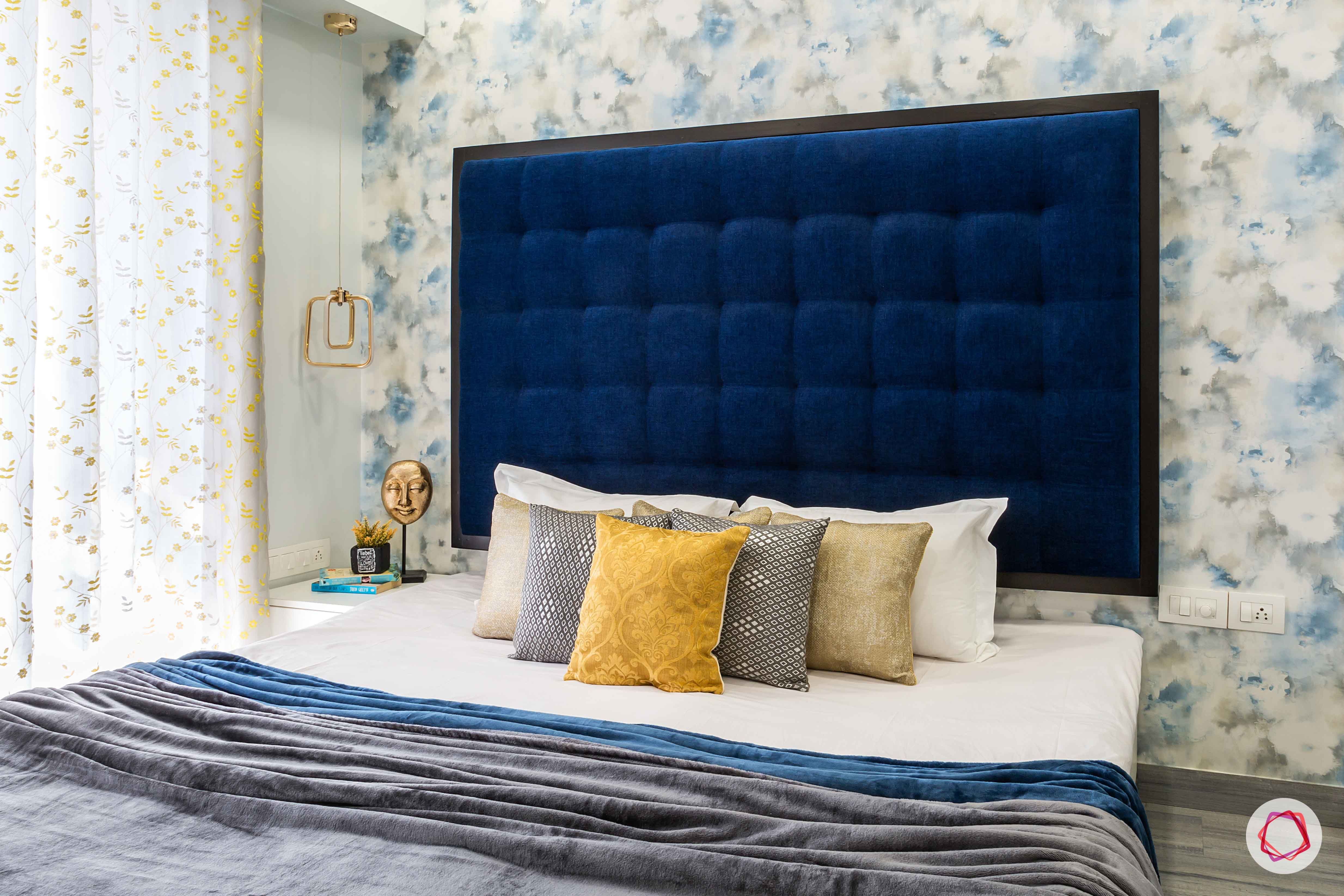 bedroom-blue-headboard-floral-wallpaper-pillows
