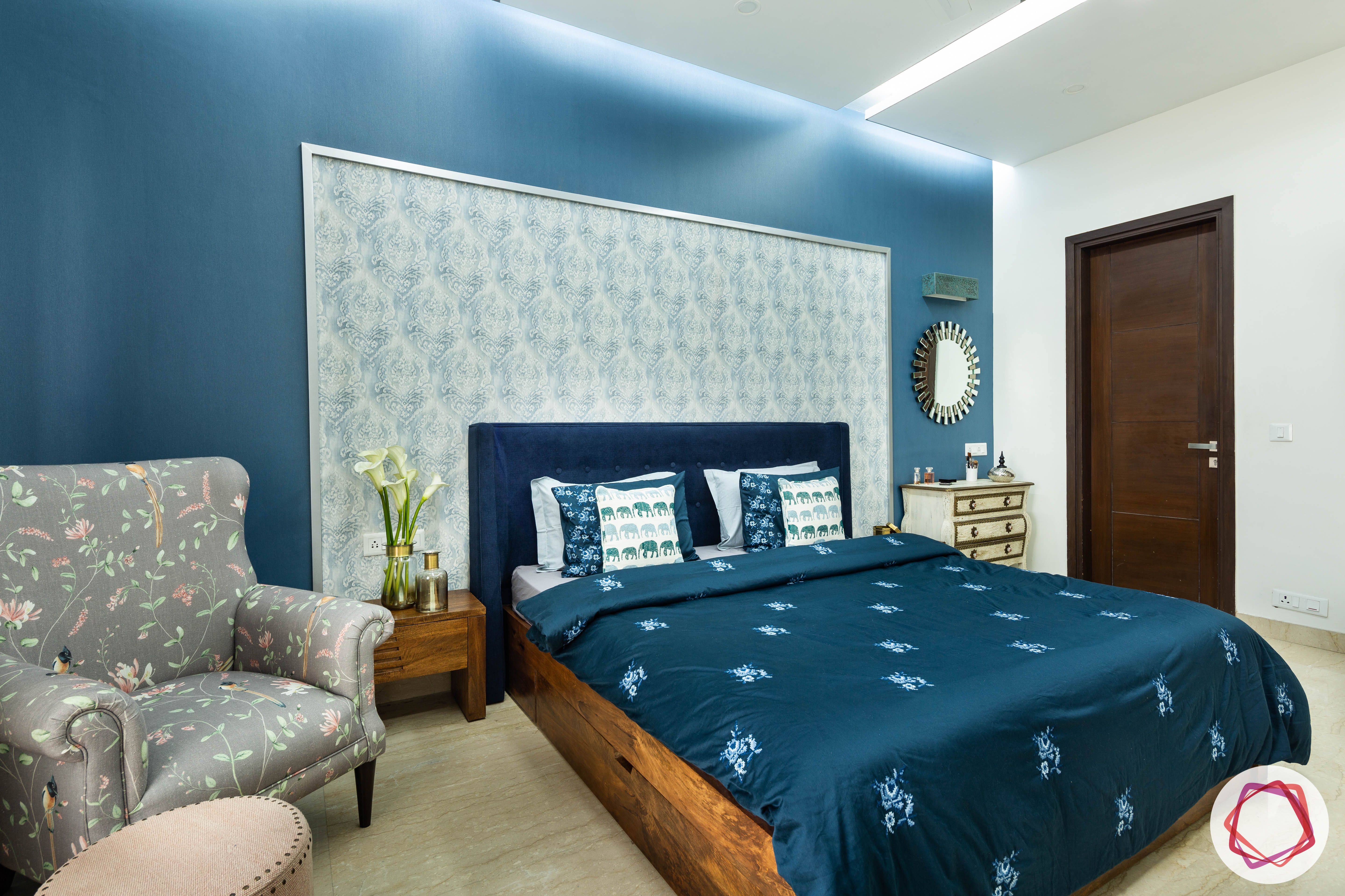 blue-wall-sheet-headboard-floral-armchair