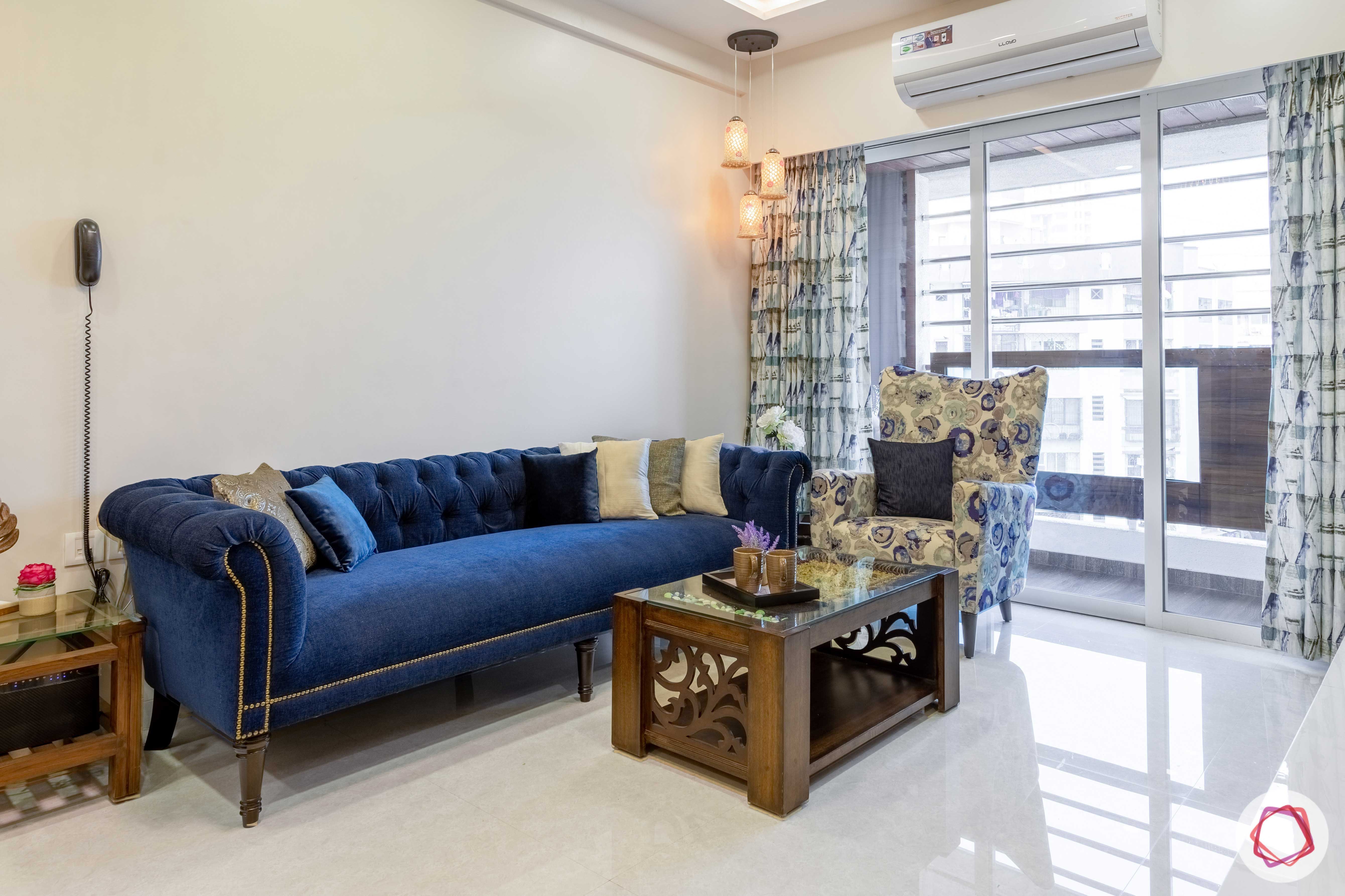 2 bhk flat interior-living room-blue sofa-printed accent chair-wooden centre table
