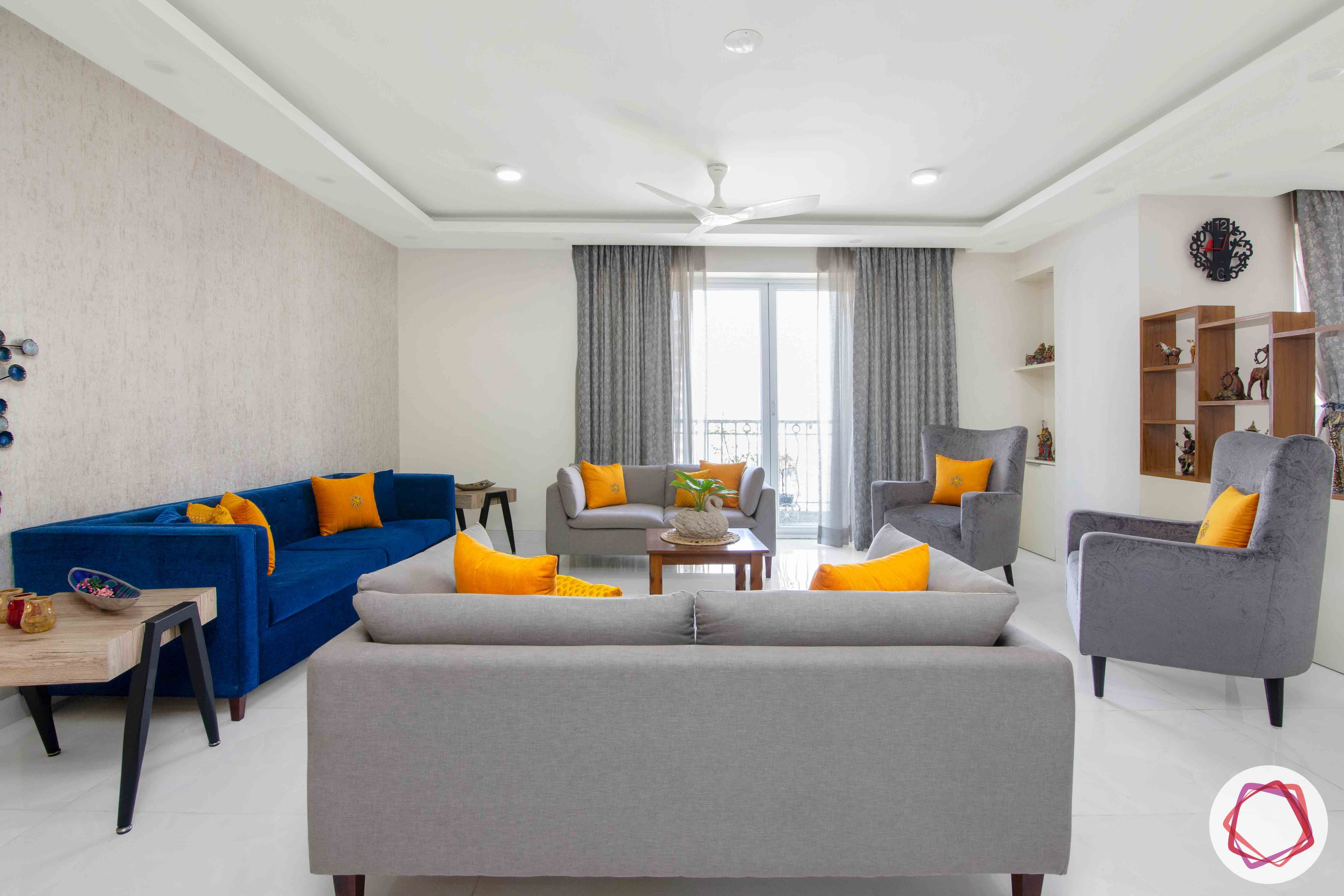 Shipra Srishti-living-room-blue-yellow-sofa-pillows-floral-accent-curtains