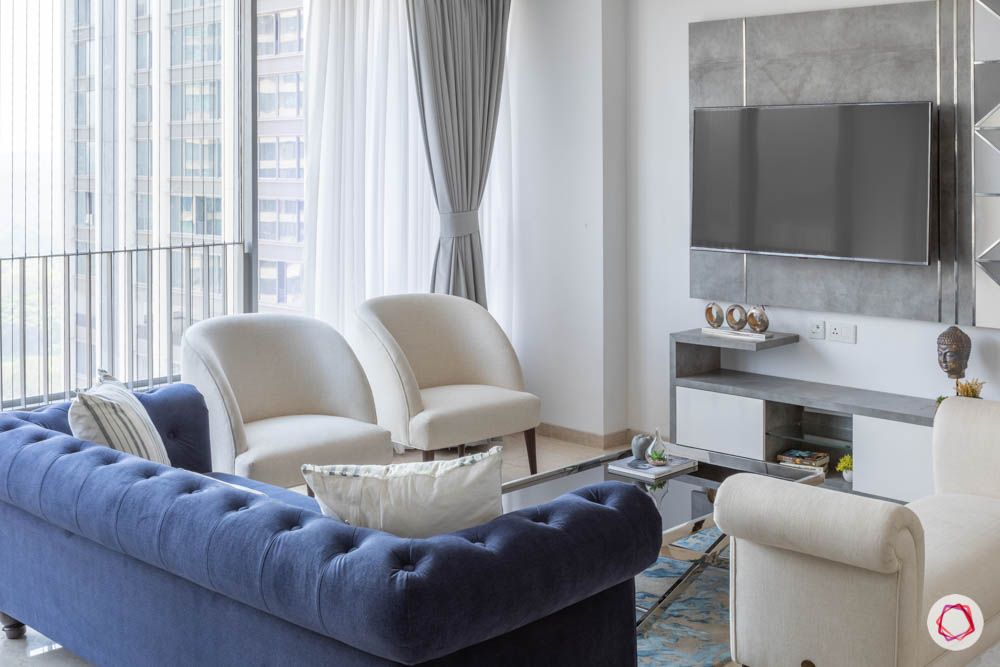 oberoi goregaon-living room-blue sofa-white chairs-laminate tv unit