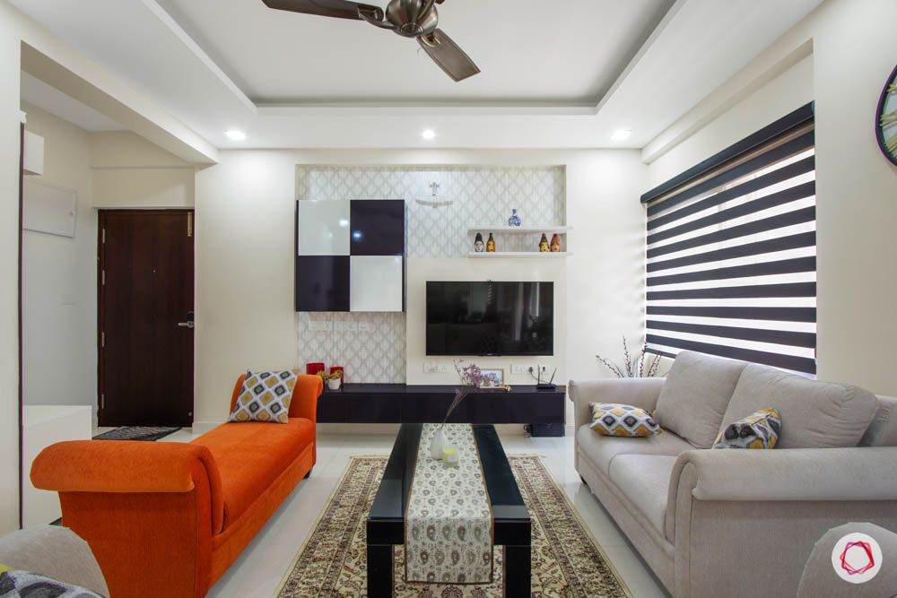Vaswani Brentwood-living-room-sofas-orange-grey-throw-pillows-coffee-table-accent-wall-TV