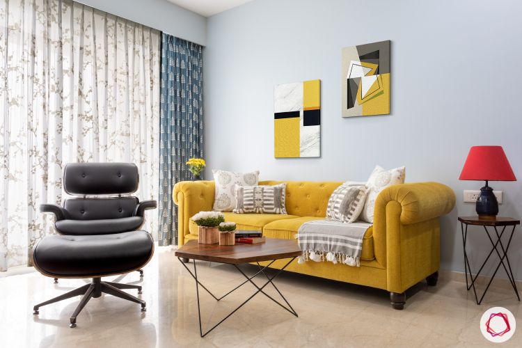 yellow sofa-popular sofa colors-white cushions-industrial table-wall frames