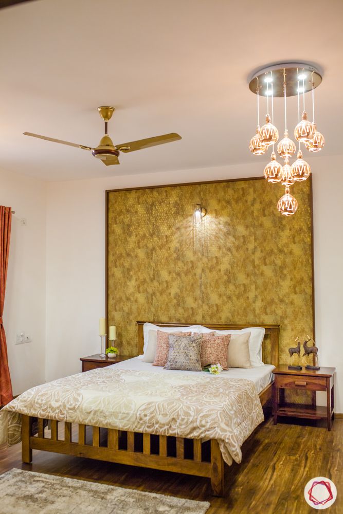 gold accent wall-wooden flooring-pendant lights-wooden bed-side table