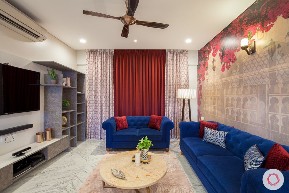 home in pune-bougainvillea wallpaper-floor lamp-blue sofa-marble center table-tv unit-grey display shelves