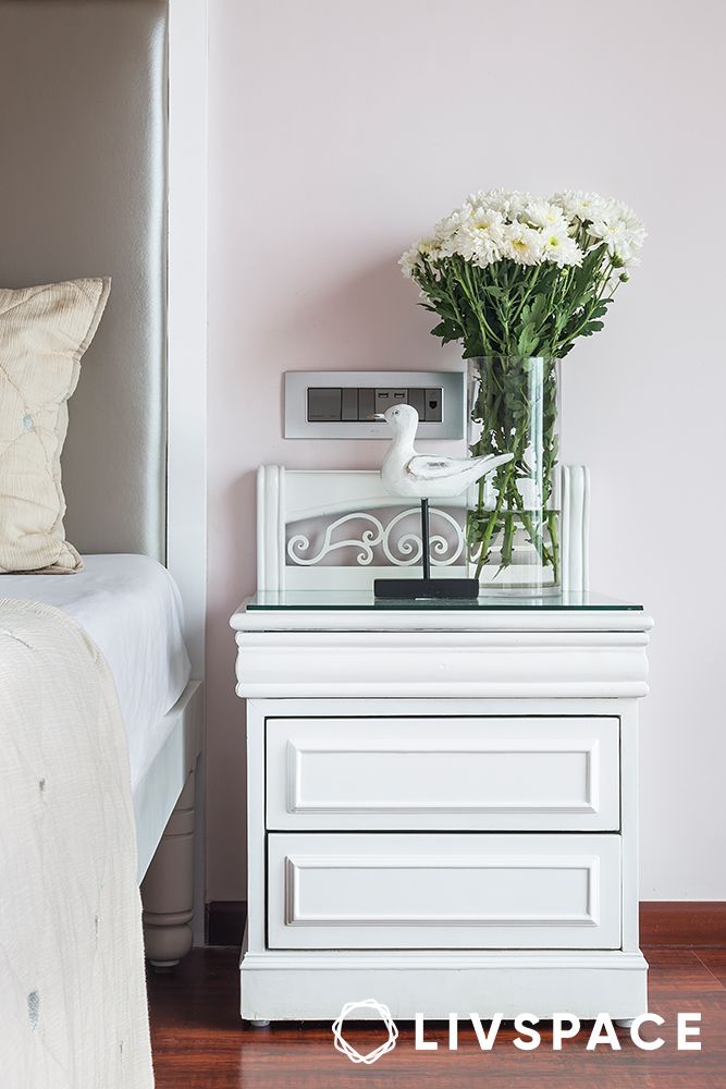 white-side-table-with-flower-vase-in-a-guest-bedroom