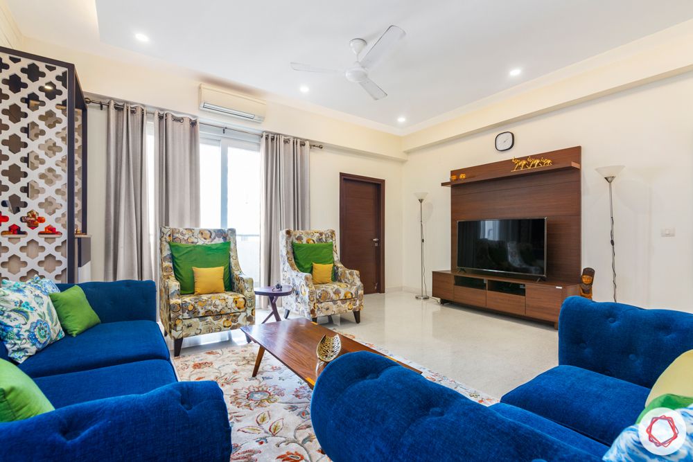 living room-blue sofa-jaali pooja unit-white exposed brick wallpaper-centre table-TV unit