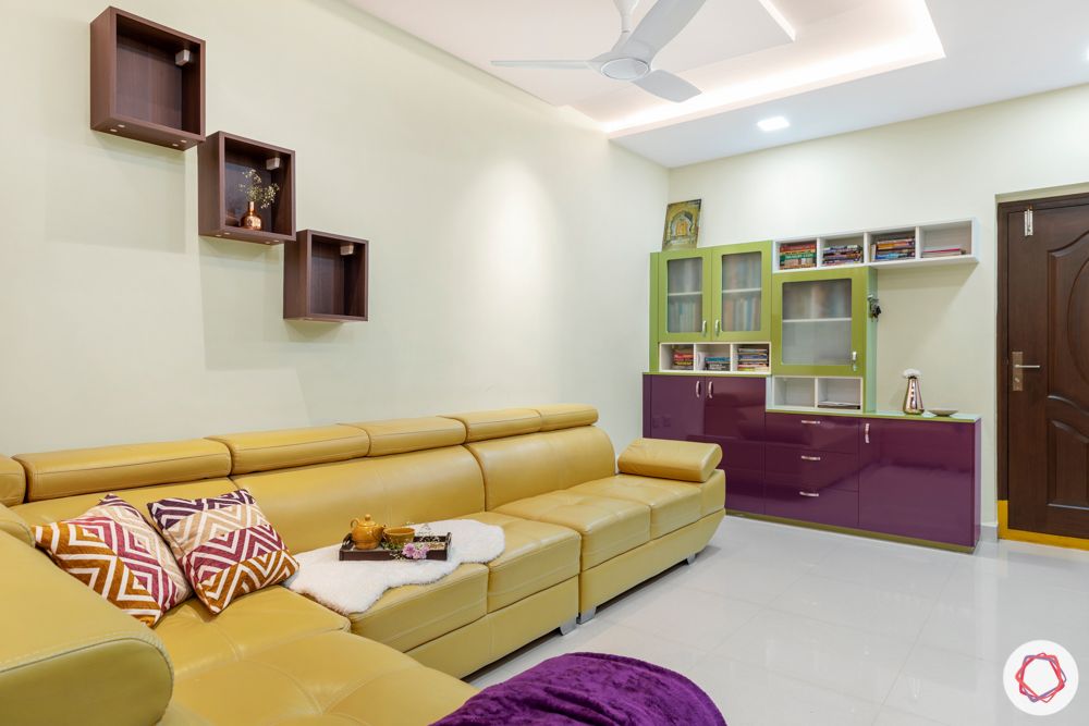 madhavaram serenity-living room-yellow sofa set-wooden partition-green and purple cabinets-bookshelf