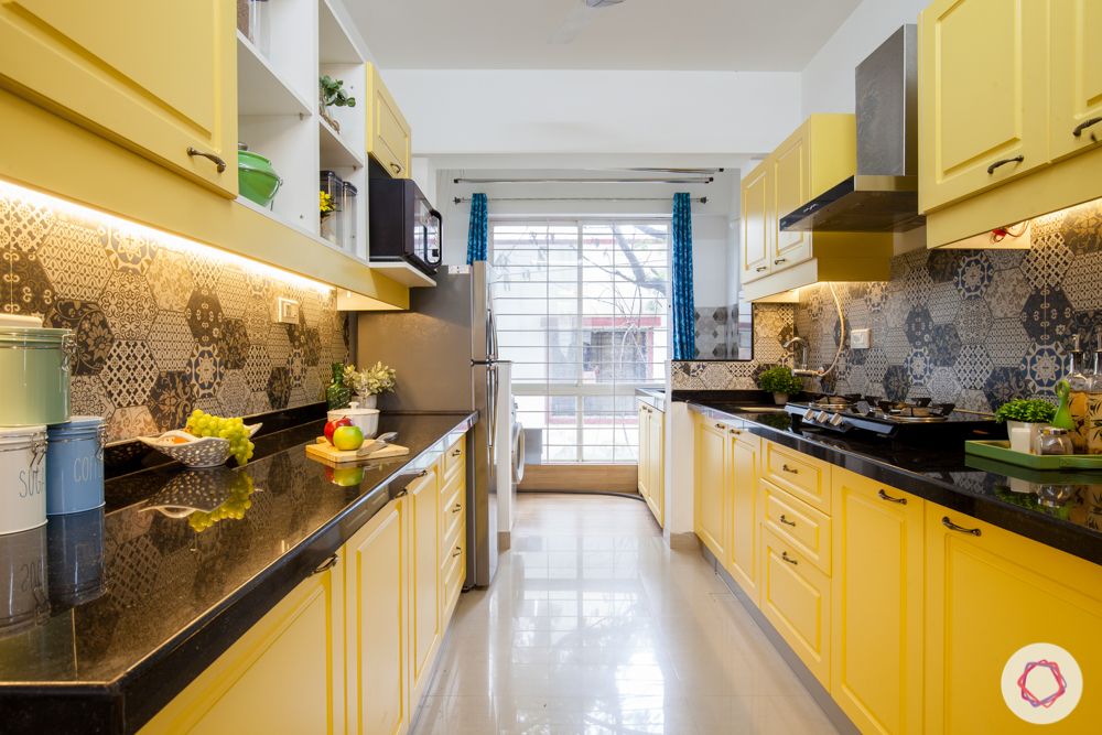 yellow-cabinets-grey-backsplash-black-countertop-profile-lights