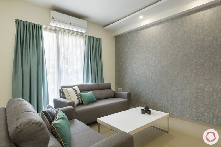 3-bhk-apartment-grey-textured-wallpaper-grey-sofa-marcel-center-table-blue-curtains