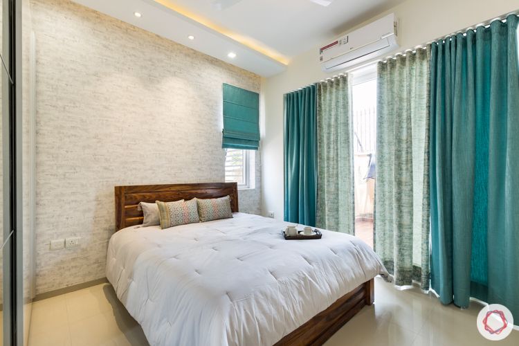 3 bhk apartment-master bedroom-exposed brick wallpaper-wooden bed-blue curtains