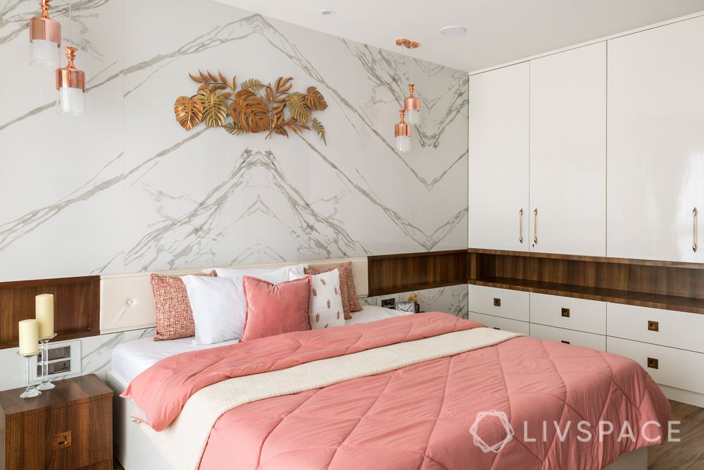 marble wall-hinged wardrobes-gold wall mount-pendant lights-pink bedded-wooden interiors