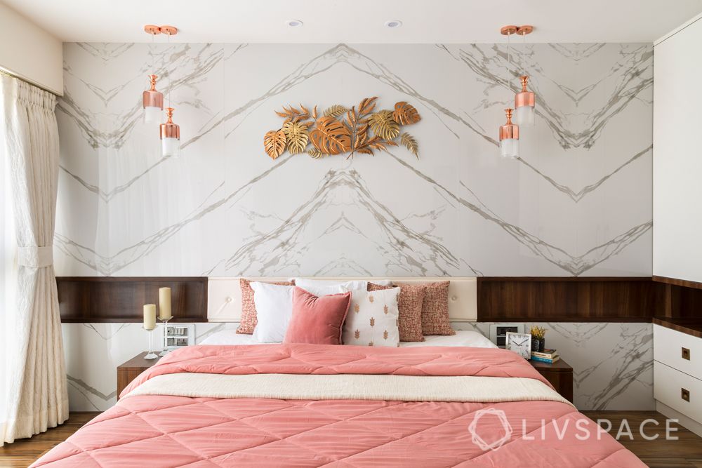 marble wall-hinged wardrobes-gold wall mount-pendant lights-pink bedded-wooden interiors