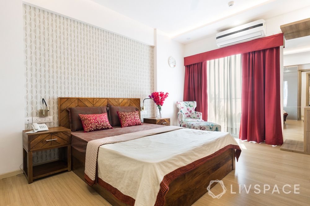 Master bedroom-patterned wallpaper-maroon curtains-wooden furniture