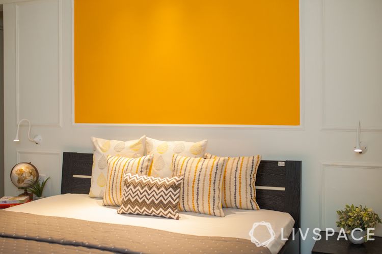 small house interior design-yellow wall-wall trims-track lights-bedside lights