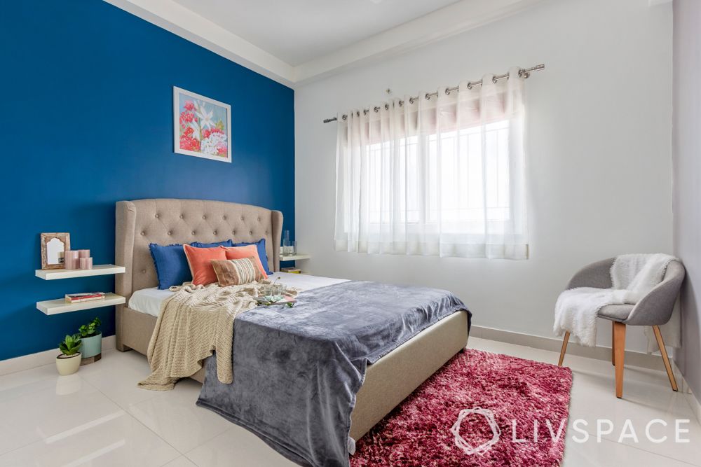 interiors in bangalore-blue painted walls-wall art-upholstered bed-white wardrobes