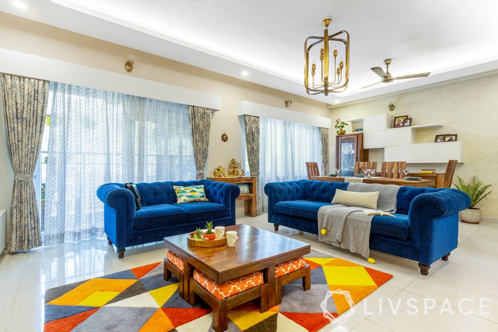 3 bhk home design-living room-blue sofa-coffee table-nested ottomans-carpet