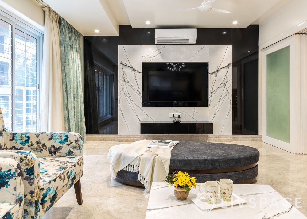 modern villa design-living room-blue sofa-floral armchairs-chandelier-marble tv unit-foyer