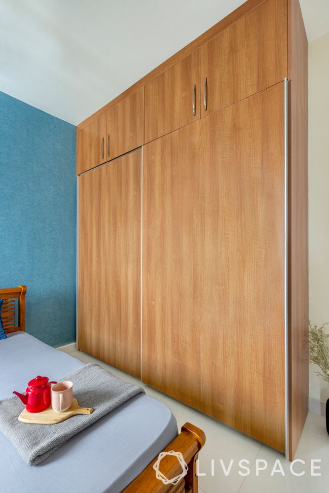 simple interior design-blue wallpaper-wooden wardrobe-wooden bed-side table