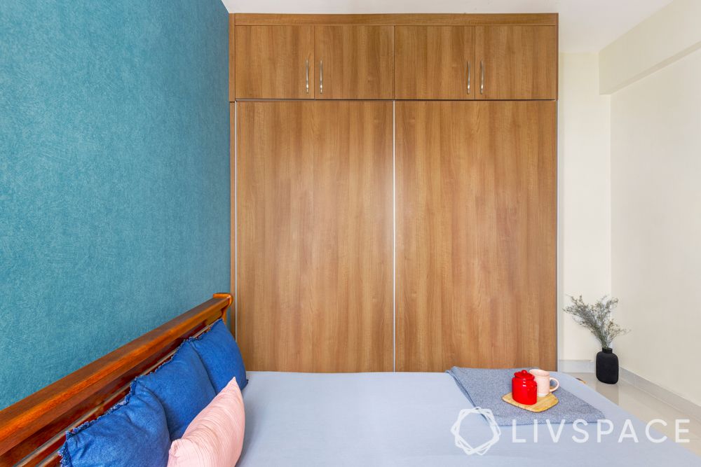 simple interior design-blue wallpaper-wooden wardrobe-wooden bed-side table