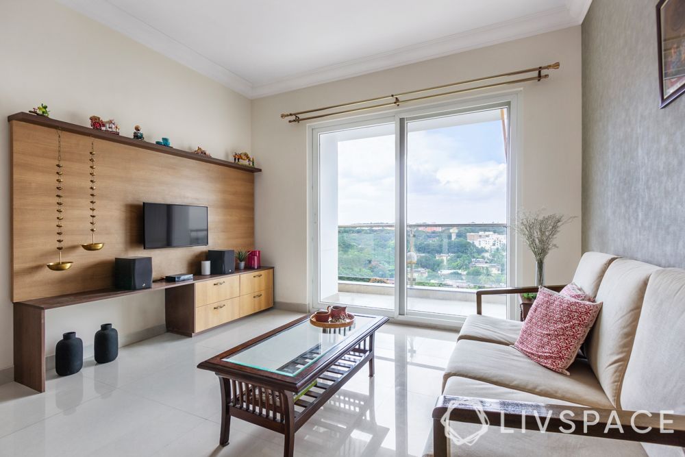 simple interior design-wooden sofa-brass lamps-wooden tv unit-coffee table-grey wallpaper