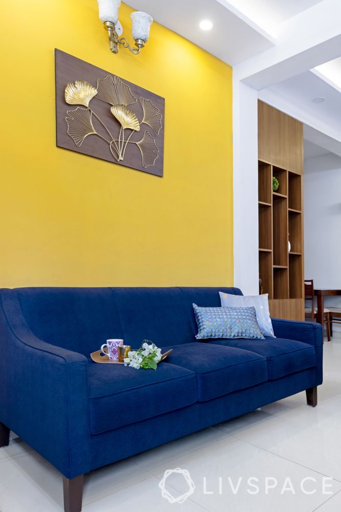 living room-yellow accent wall-blue sofa-laminate partition