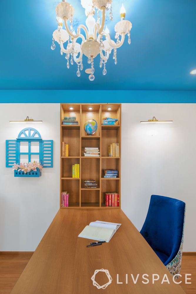travel-themed interior design-blue and white chair-wooden desk and bookshelf-painted ceiling-white walls