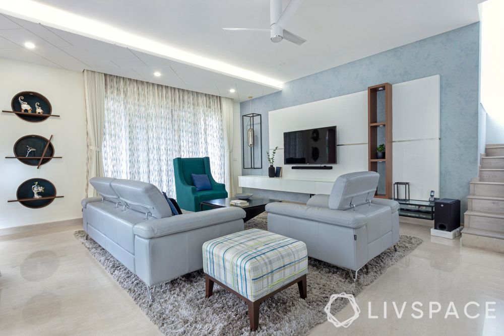 villa house design-blue armchair-tv unit design-coffee table-light blue sofa-textured wall paint

