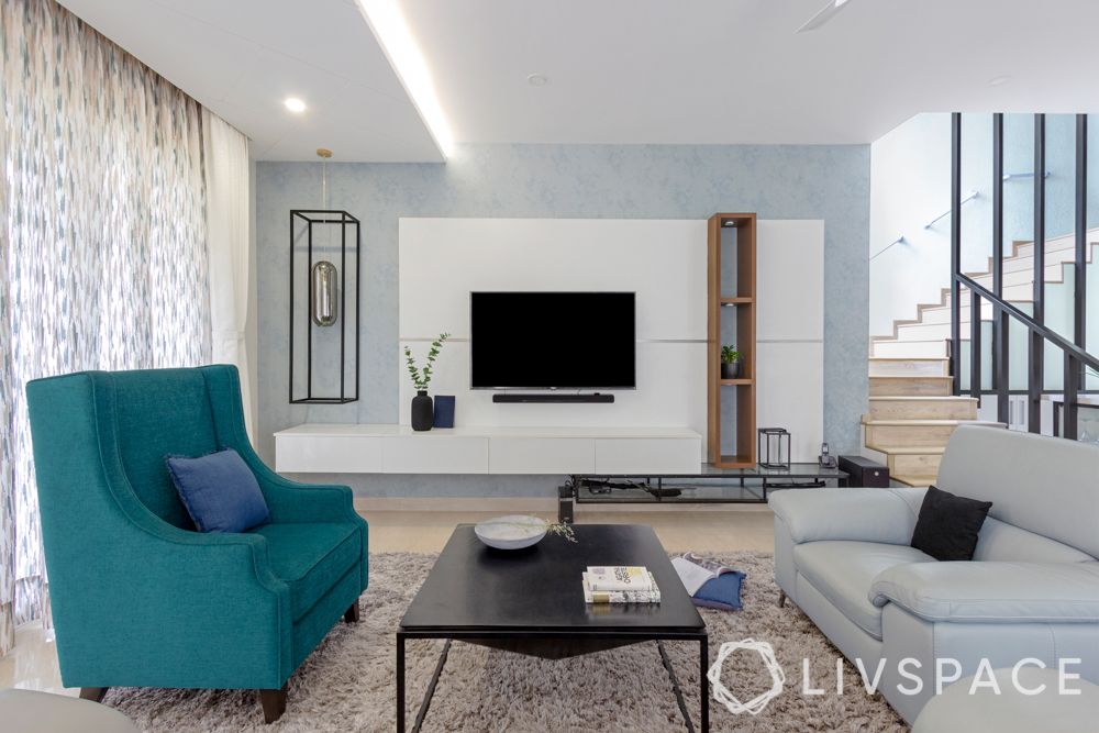 villa house design-blue armchair-tv unit design-coffee table-light blue sofa-textured wall paint