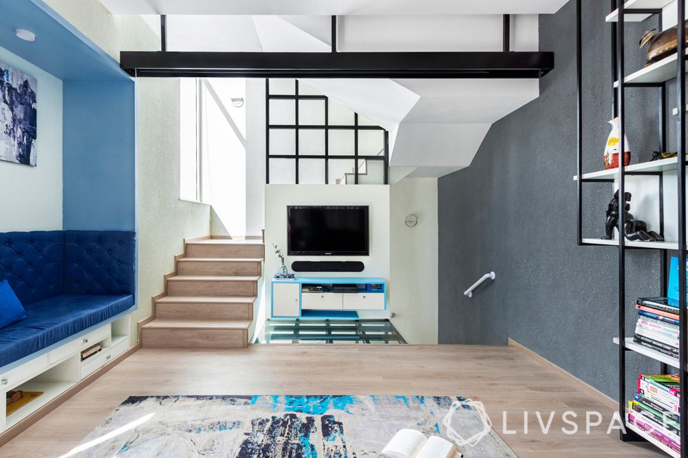 villa house design-blue sofa-niche seating-pop false ceiling-extended flooring-projector-bookshelf