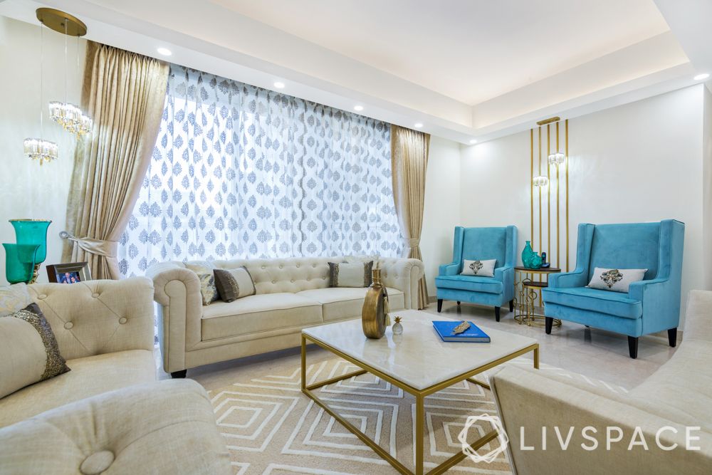 interior design company in gurgaon-living room--neutral sofa-pattern rug-gold wall trims-textured wallpaper