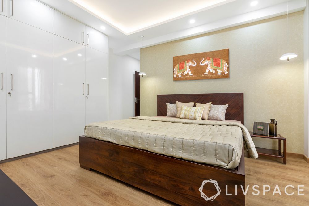 3 bhk design-laminate wardrobes-frosted white-hinged storage-wooden bed-gold wallpaper